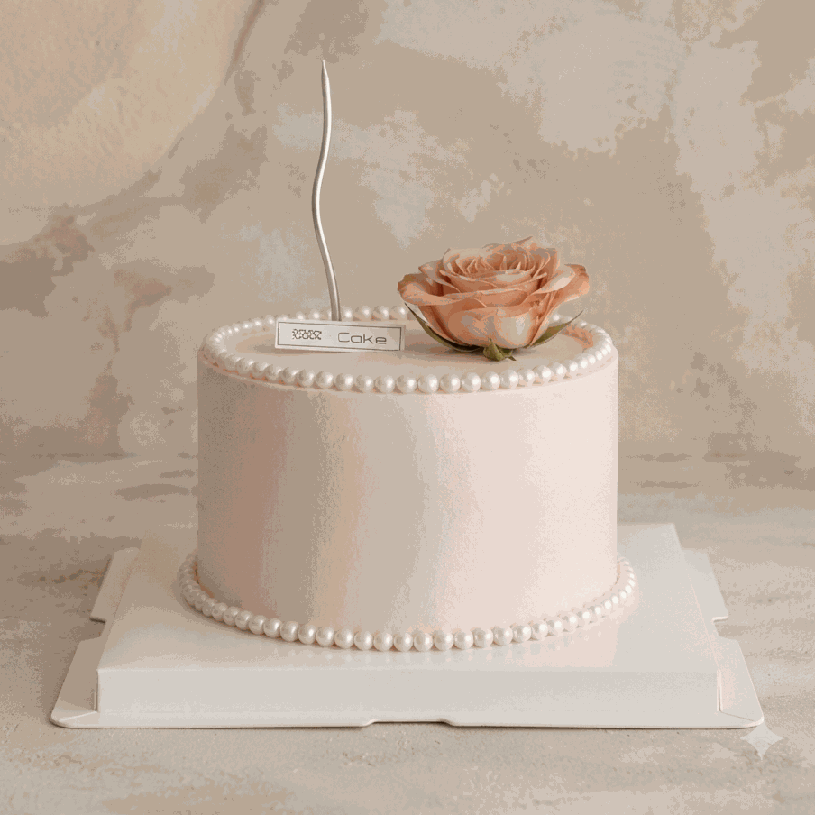 Elegant blush pink Pearl & Rose Cake with edible pearl borders, fresh dusty rose, and silver candle centerpiece