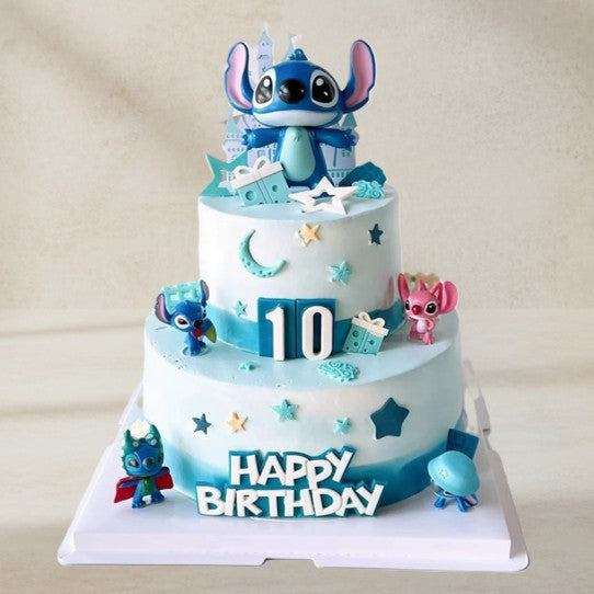Two-tier magical stitch cake with 3d stitch figurines and blue ombre frosting