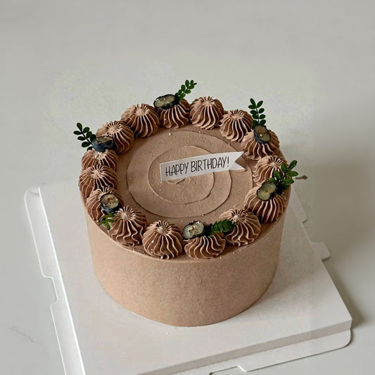 Elegant Chocolate Swirl Birthday Cake topped with chocolate rosettes, blueberries, and greenery, perfect for celebrations.