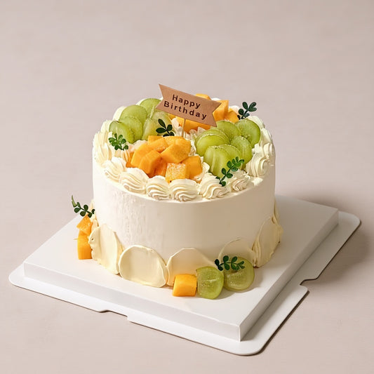 Golden Grove birthday cake with ivory-white frosting, fruit toppings, and a 'Happy Birthday' tag.