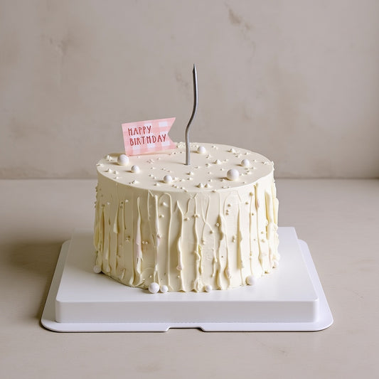 Minimalist mocha harmony cake with ivory-white frosting and birthday flag on top, perfect for celebrations.