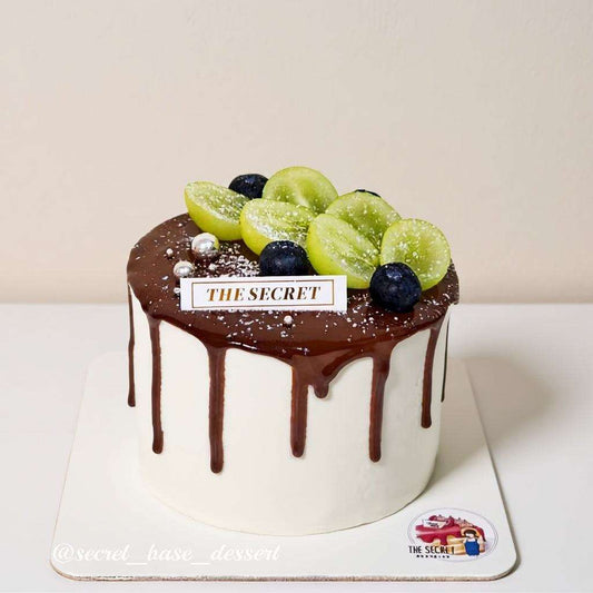 Chocolate cake with dark ganache drip, Shine Muscat grapes, blueberries, and pearl accents