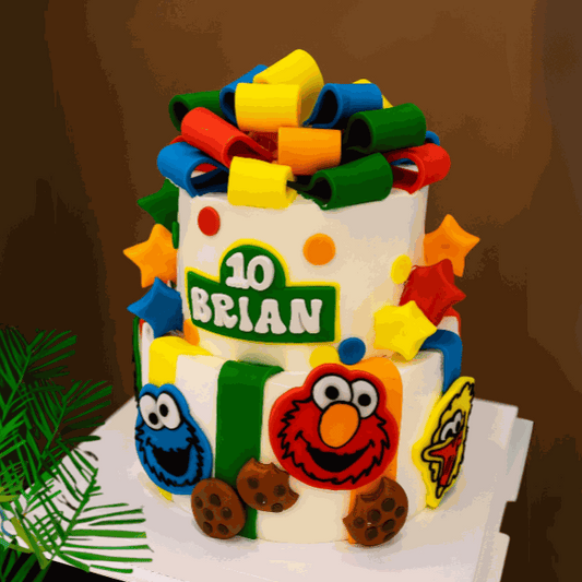 Colorful Sesame Pop Chocolate Cake with Elmo, Cookie Monster, and Big Bird fondant decorations and multi-colored fondant bow by GoodDay bakery