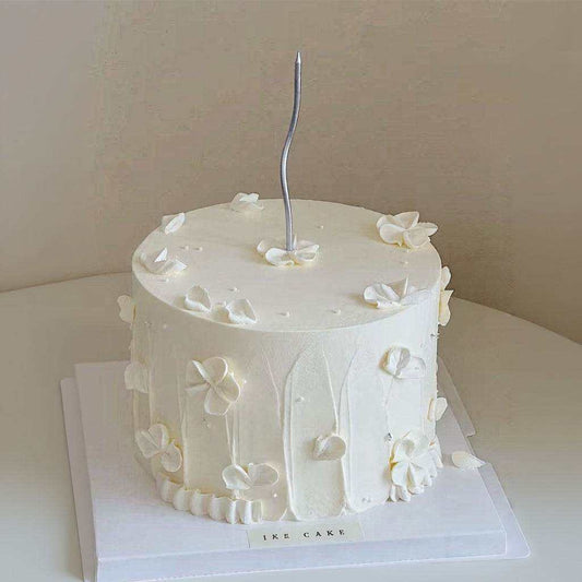 Elegant ivory floral cake with 3D buttercream blossoms and silver candle