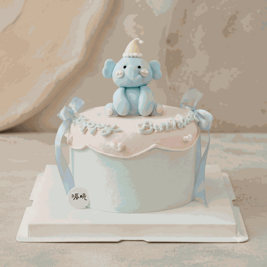 Pastel baby elephant cake with 3D blue elephant topper and pink scalloped trim
