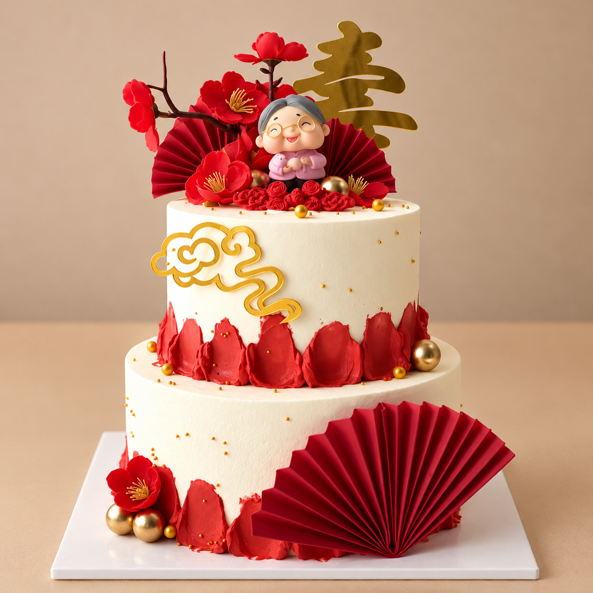 Ivory and red two-tier longevity cake with grandmother figure, gold 寿 topper, red blossoms and folded fans — Good Day Bakery Singapore
