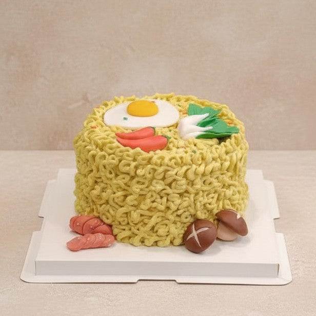 Ultra-realistic instant noodle cake with buttercream noodles, fondant egg, chilies, bok choy, sausages, and mushrooms