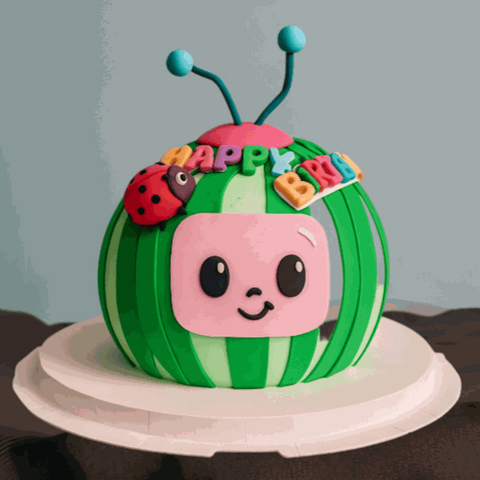3D Ladybug Cake shaped like CoComelon watermelon mascot with colorful HAPPY BIRTHDAY lettering and teal antennae topper