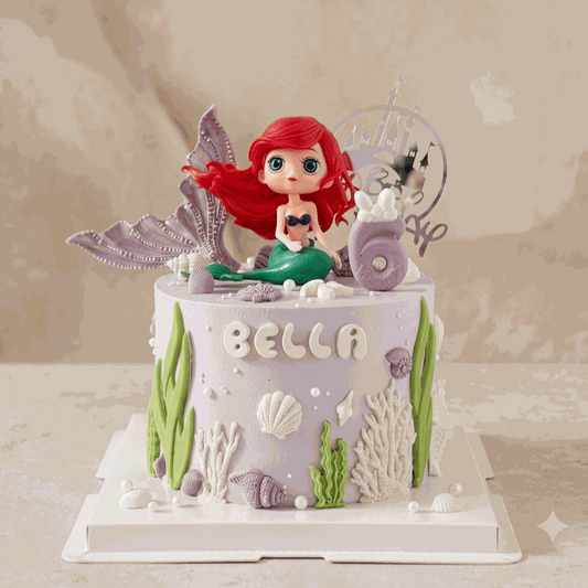 Lavender mermaid cake with red-haired figurine and undersea decorations