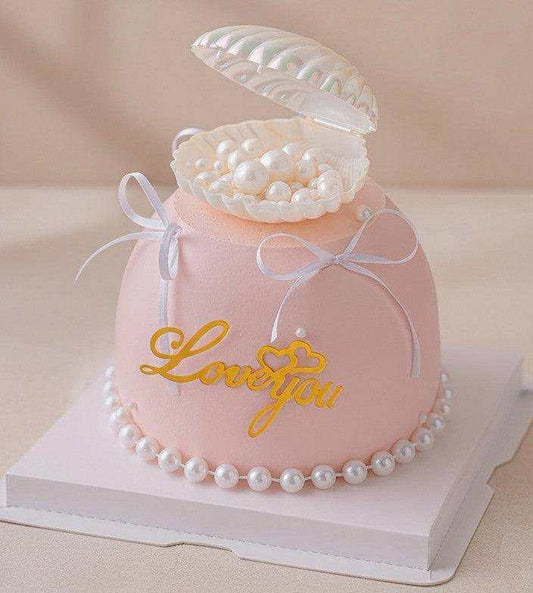 Pearl cake with seashell topper and edible pearls