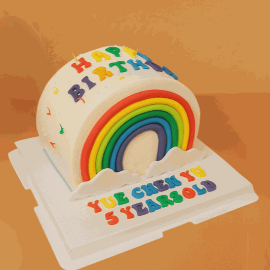 Rainbow cake with colorful fondant arch, fluffy clouds, and "Happy Birthday" lettering on ivory cream finish