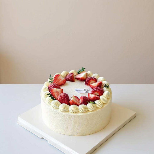 Fresh strawberry cake with piped cream and strawberry halves
