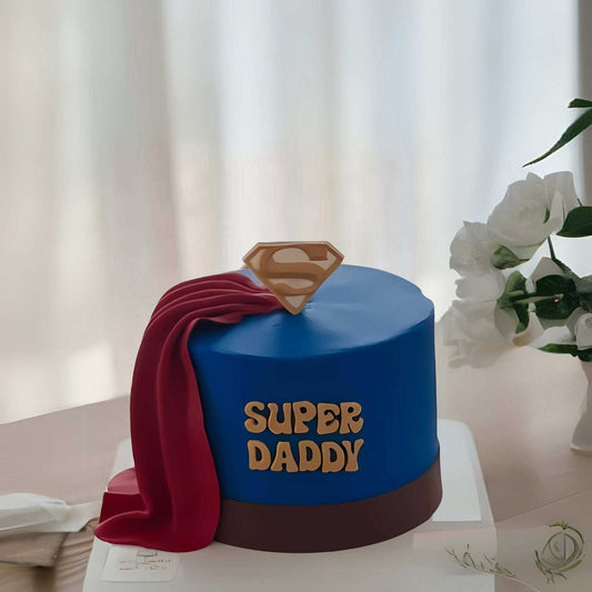 Super Daddy Cake with blue fondant, red cape, and golden emblem